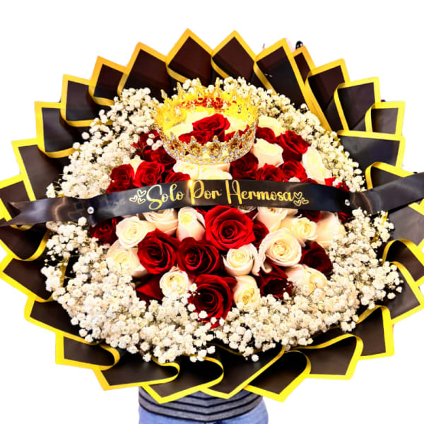 Round bouquet of red and cream roses with a crown topper and black ribbon