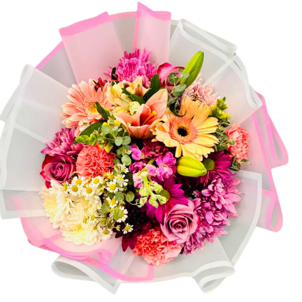 Mixed bouquet of pink, peach, and yellow flowers wrapped in white and pink paper