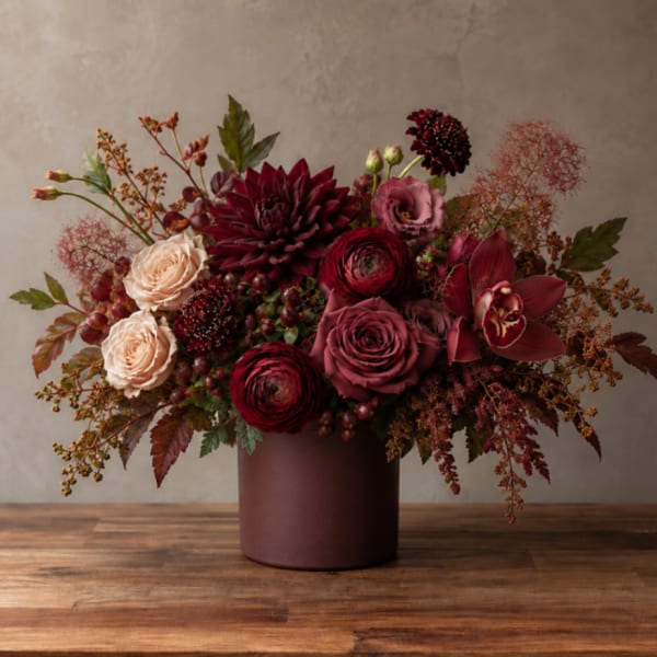 Burgundy and blush floral arrangement in a round vase