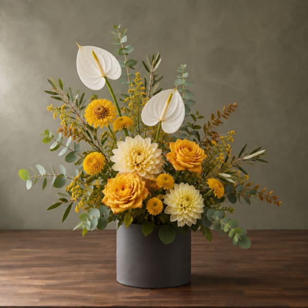 Yellow and white floral arrangement in a gray vase