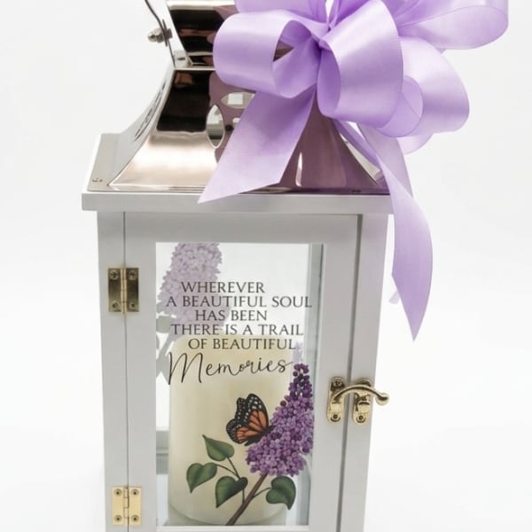 White memorial lantern with a purple ribbon bow and printed candle inside