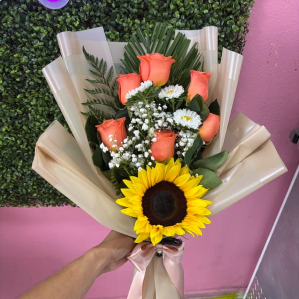 Bouquet of orange roses and a sunflower wrapped in beige paper