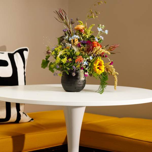 Mixed bouquet in a dark vase on a white table