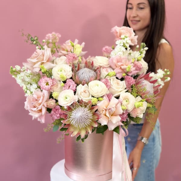 Large pastel bouquet in a pink hatbox with a ribbon