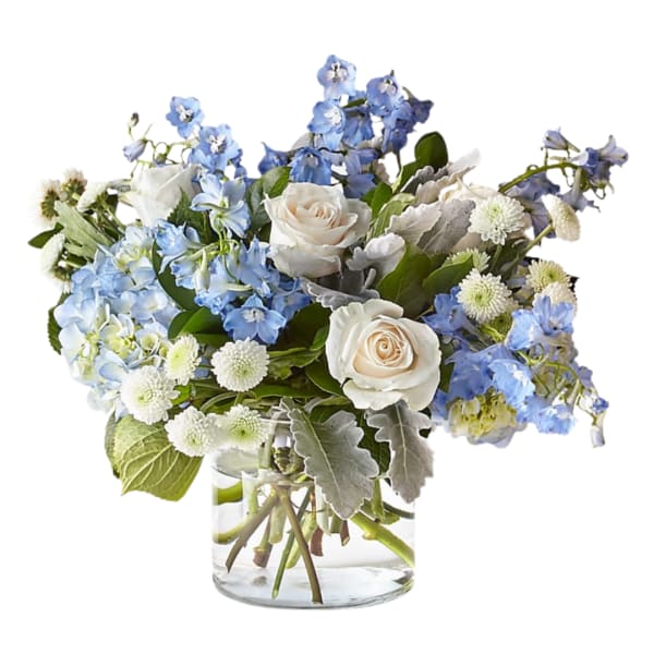 Blue and white bouquet with roses in a clear glass vase