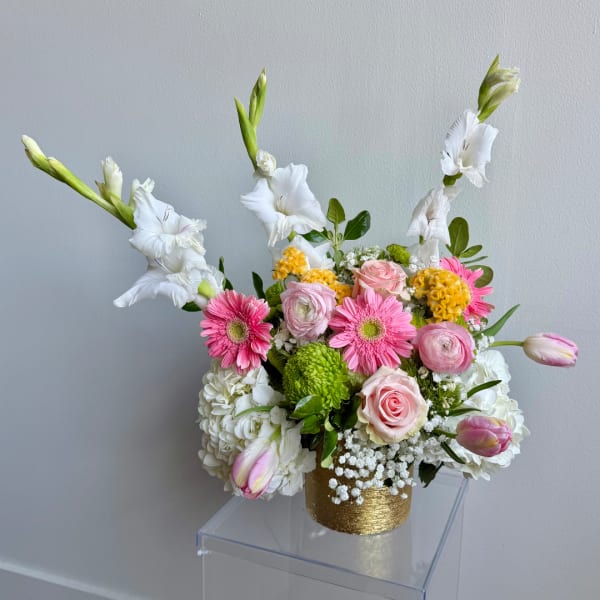Pink and white mixed flower arrangement in a gold vase