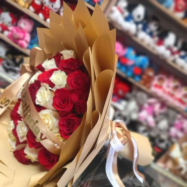 Bouquet of red and white roses wrapped in brown paper