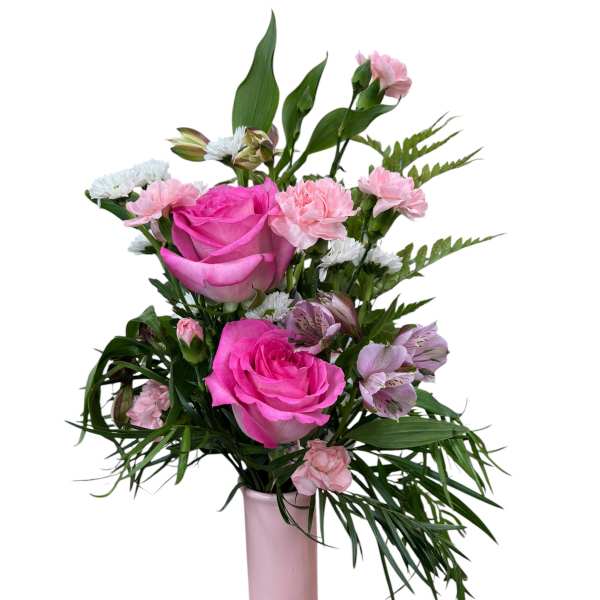 Pink roses and mixed blooms arranged in a tall pink vase