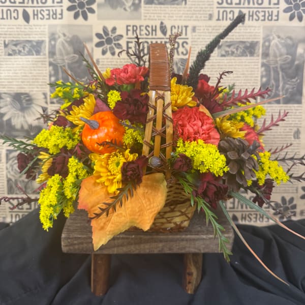 Autumn flower basket with a small pumpkin and yellow blooms