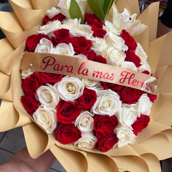 Bouquet of red and white roses wrapped in tan paper with a ribbon