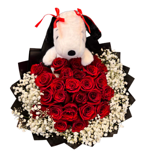 Stuffed Snoopy sits atop a heart-shaped bouquet of red roses