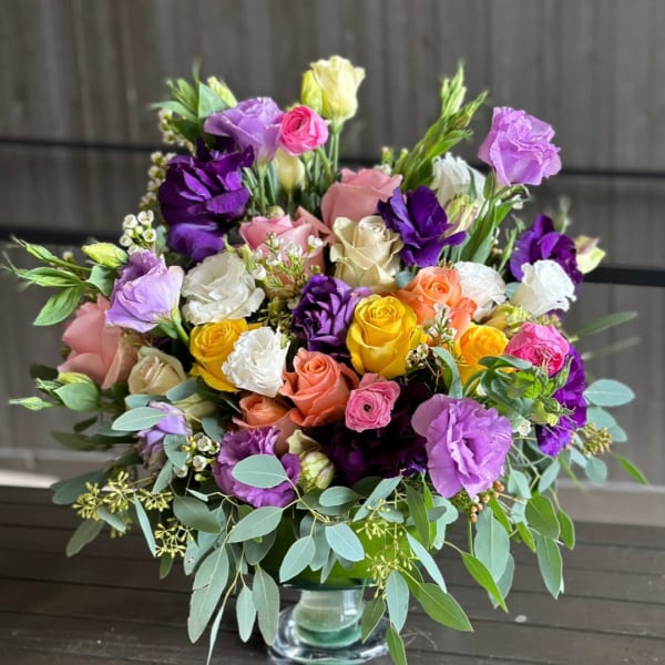 Mixed bouquet of roses and lisianthus in a glass vase