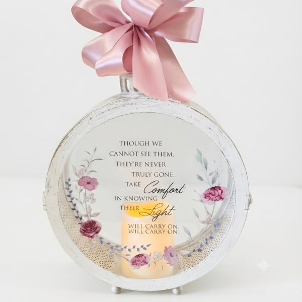 Round memorial plaque with a pink ribbon bow and candle design