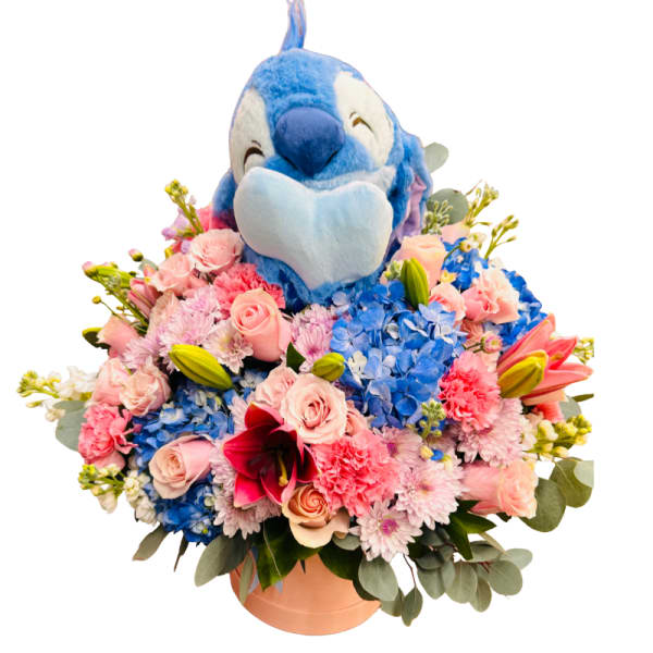 Blue plush bird sitting in a pink flower arrangement