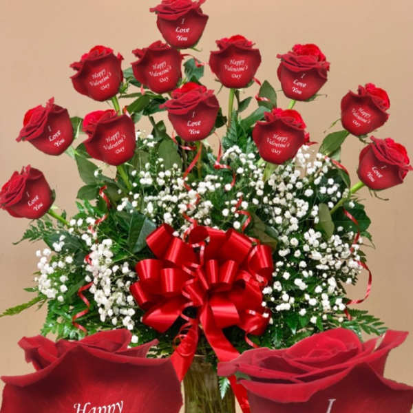 Red roses with baby’s breath in a glass vase and a large red bow