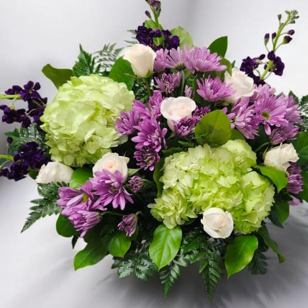 Bouquet of green hydrangeas, purple daisies, and white roses