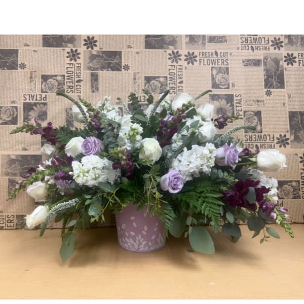 Lavender and white floral arrangement in a pink vase
