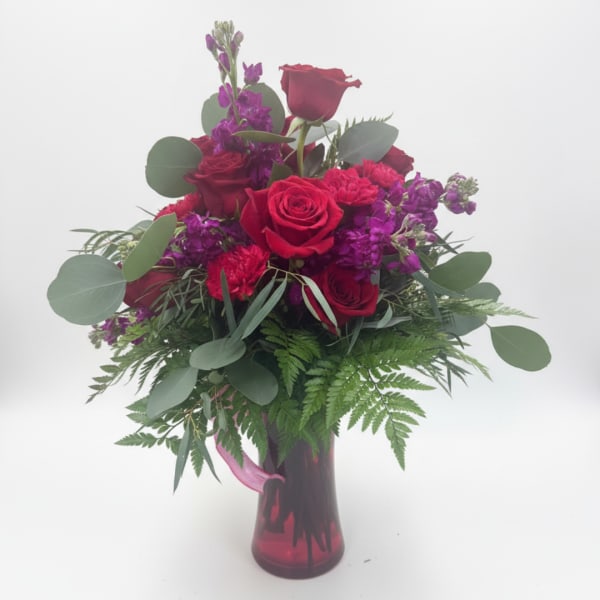 Red roses and purple flowers in a burgundy vase