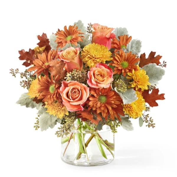 Bouquet of orange and yellow flowers in a clear glass vase