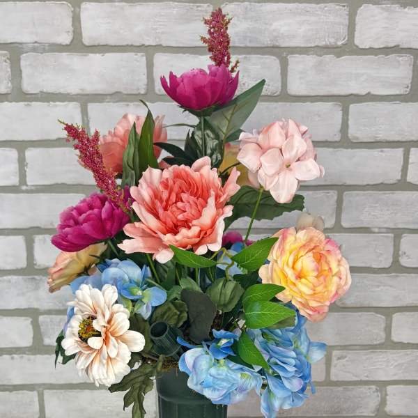 Colorful mixed flower arrangement in a tall green vase