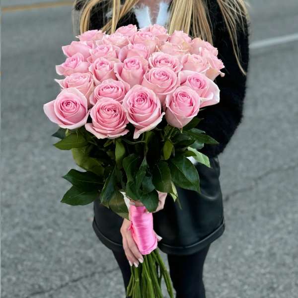 Handheld bouquet of pink roses with a pink ribbon wrap