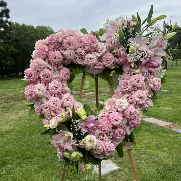 Pink floral heart wreath on a wooden easel outdoors