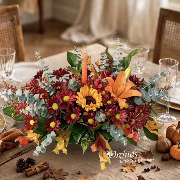 Autumn centerpiece with orange lily and red daisies on a dining table