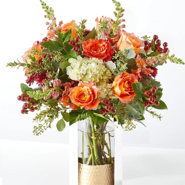 Orange roses and white hydrangea in a clear glass vase