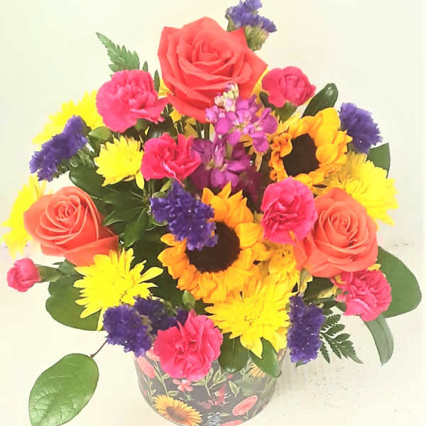 Colorful mixed bouquet with roses, sunflowers, and carnations in a patterned vase