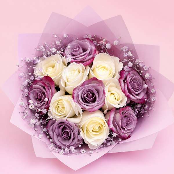 Bouquet of lavender and cream roses with baby's breath in pink wrap