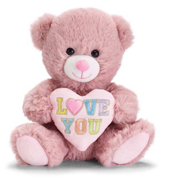 Pink plush teddy bear holding a pastel heart pillow with the words LOVE YOU.