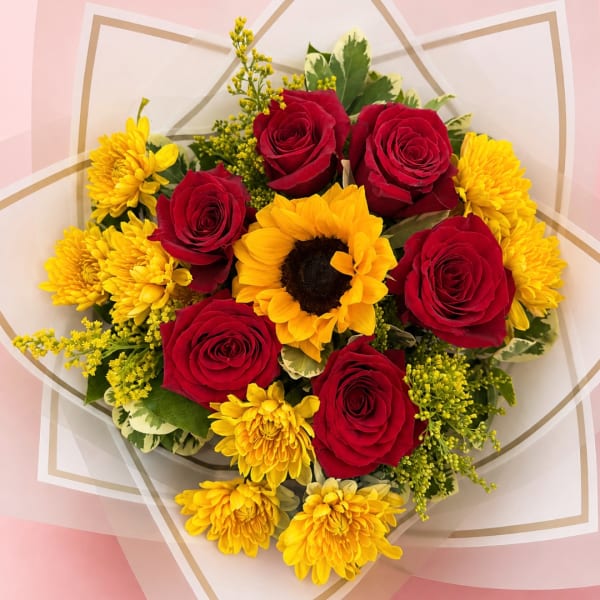 Bouquet of red roses and yellow chrysanthemums with a sunflower center