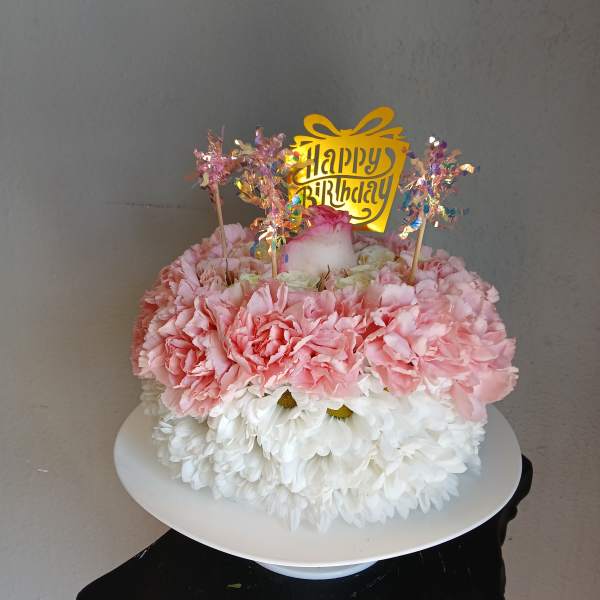 Pink and white flower cake with a happy birthday topper
