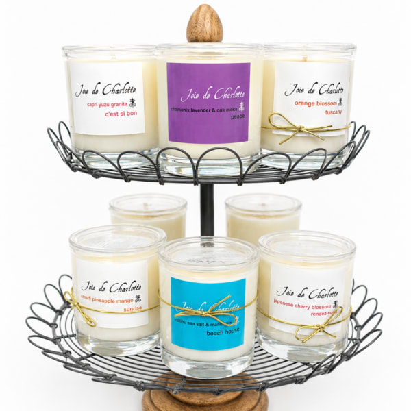 Set of scented candles in glass jars on a two-tier wire stand