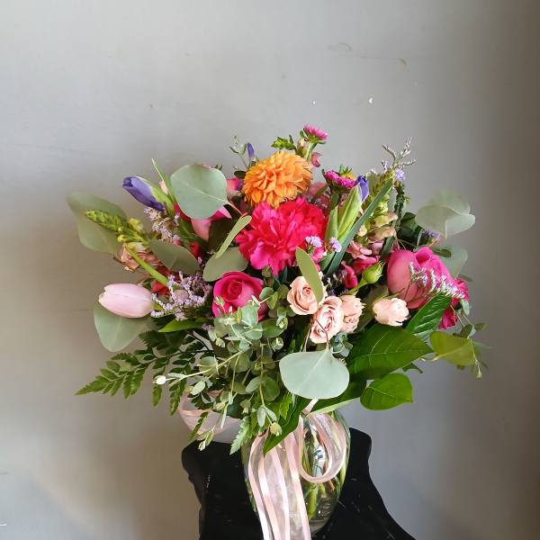 Mixed bouquet in a glass vase with pink, orange, and purple flowers