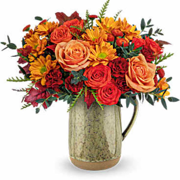 Bouquet of orange and red flowers in a rustic ceramic pitcher