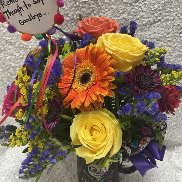 Colorful mixed bouquet in a decorated mug with a memorial sign