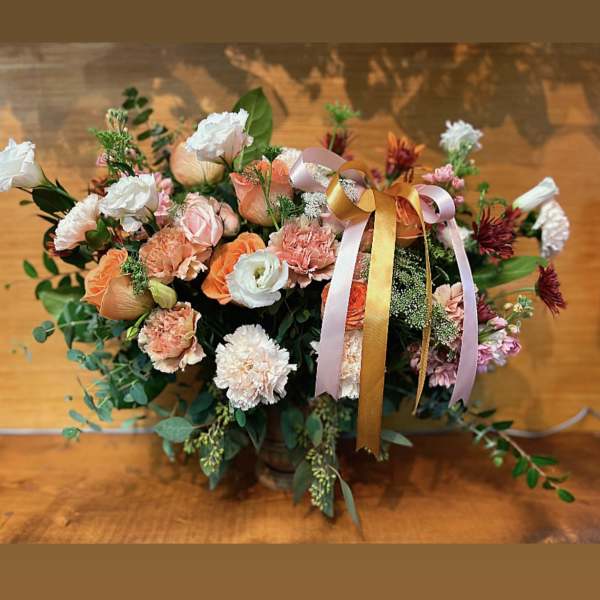 Peach and white mixed flower arrangement with ribbon in a vase