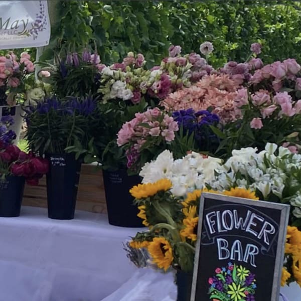Assorted bouquets in buckets at a flower bar with a Cape May Lavender Farm sign