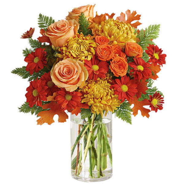 Autumn bouquet of roses and daisies in a clear glass vase