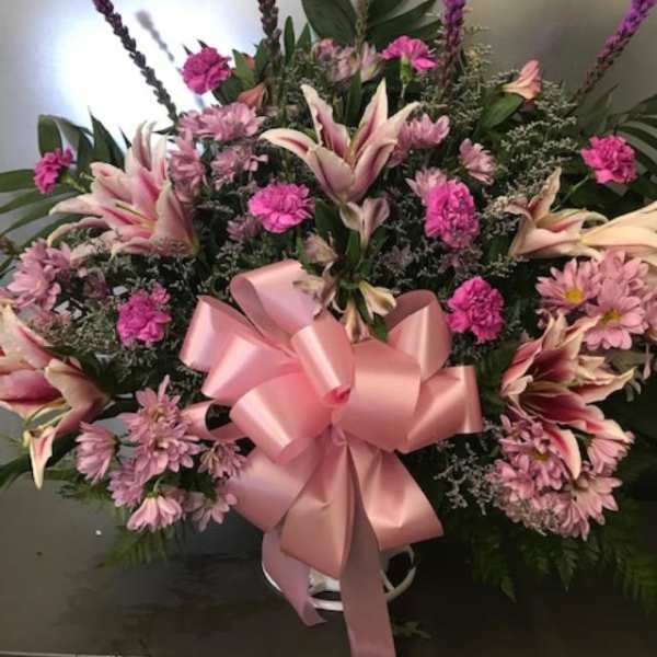 Pink and white floral spray with a large pink ribbon