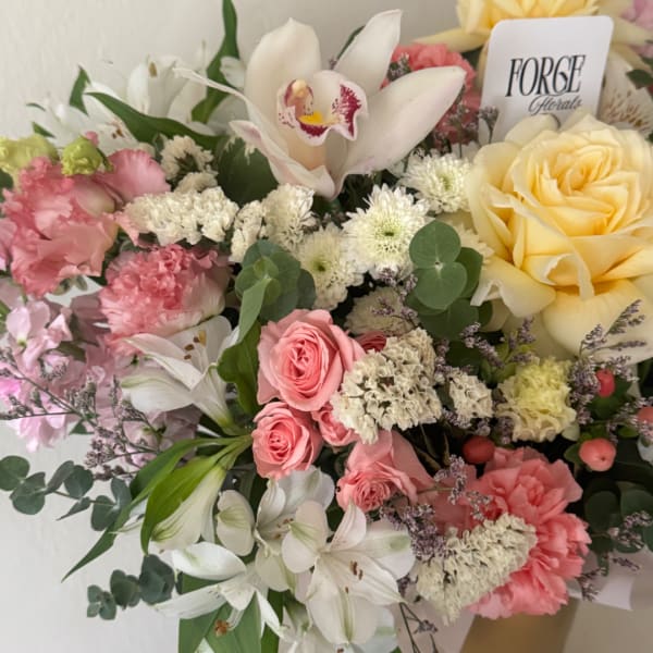 Mixed bouquet with roses, lilies, and orchids in pink, white, and yellow