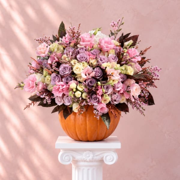 Pink and lavender rose bouquet arranged in a pumpkin container