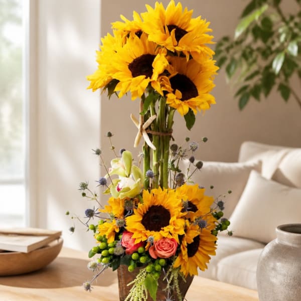 Tall sunflower arrangement with roses and orchids in a vase