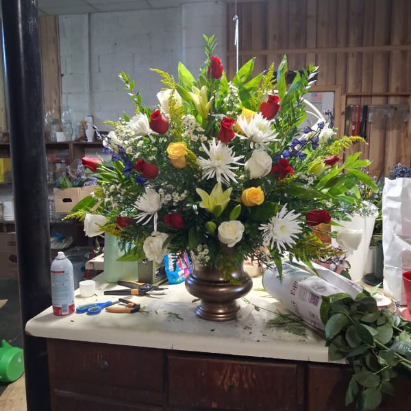 Large mixed bouquet in a brown vase with red, white, yellow, and purple flowers