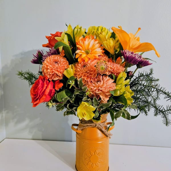 Mixed orange and yellow bouquet in a painted metal vase