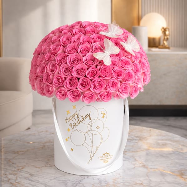 Pink rose arrangement in a white birthday box with butterfly accents