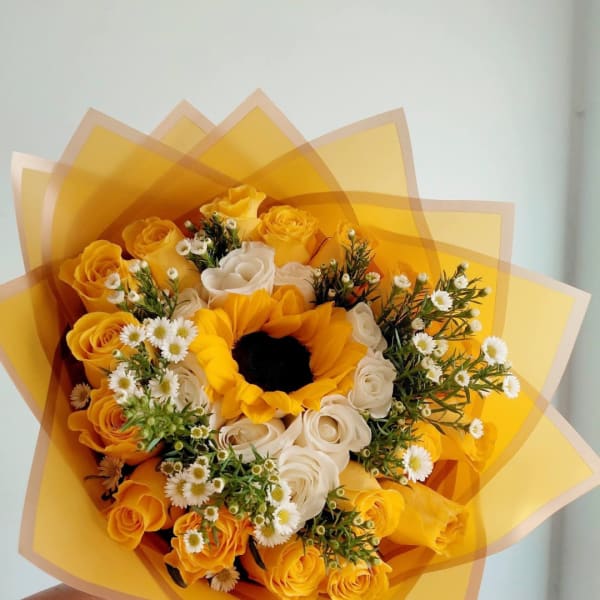 Bouquet of yellow and white roses with a sunflower center