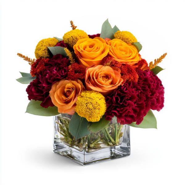 Orange roses and burgundy carnations in a clear square vase