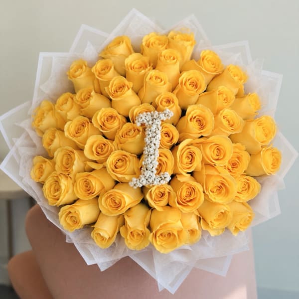 Bouquet of yellow roses with a white letter I centerpiece